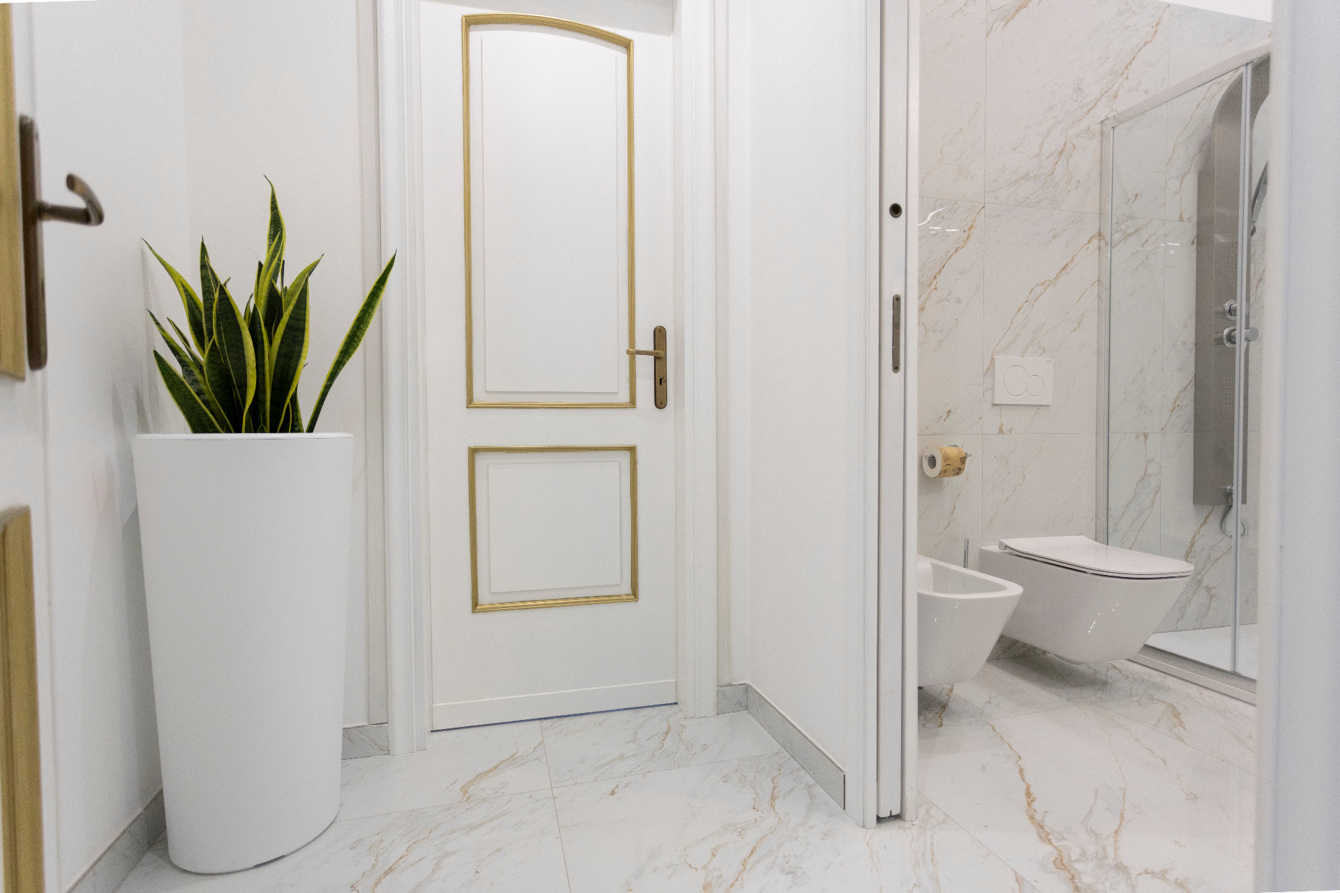 Suite Perla - bagno in marmo con porta laccata dai dettagli oro, doccia walk-in e sanitari sospesi