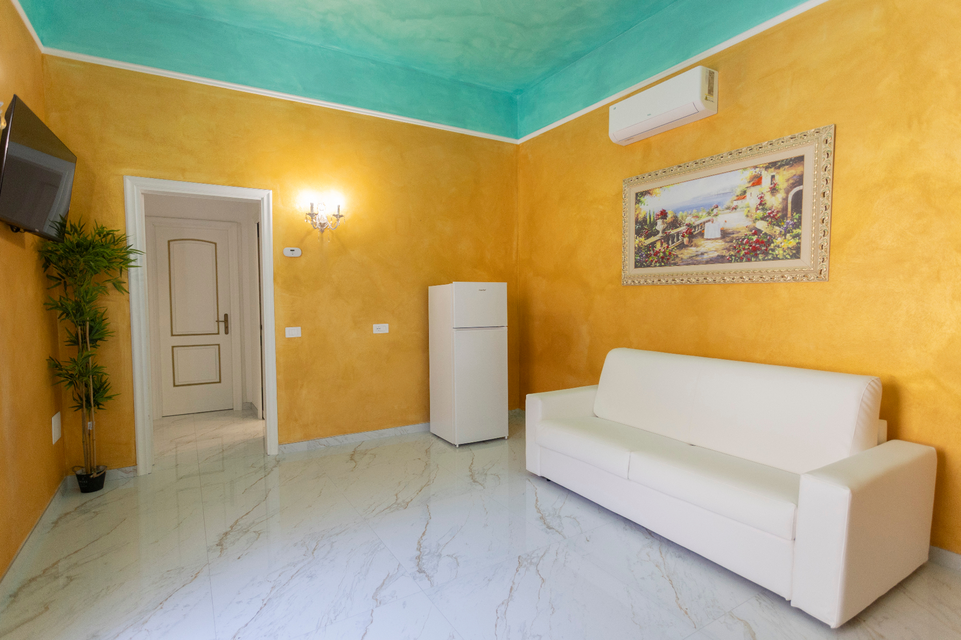 Suite Perla - salotto con divano bianco, pareti oro satinato e soffitto acquamarina