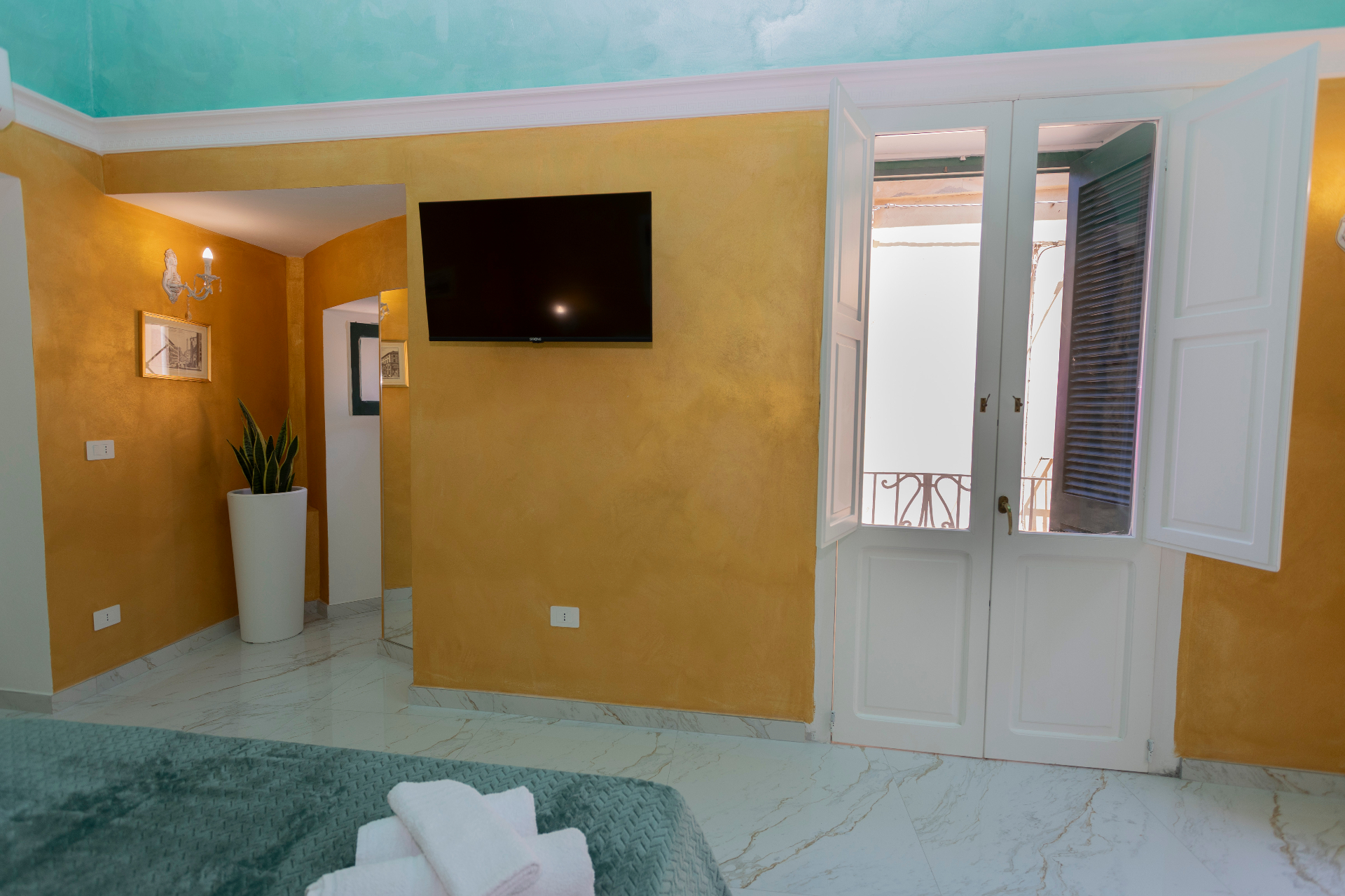 Suite Smeraldo - pareti color oro, Smart TV e porta finestra sul balcone