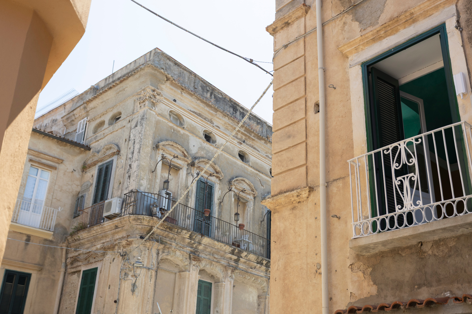 Palazzo storico di Tropea con balconi e persiane verdi
