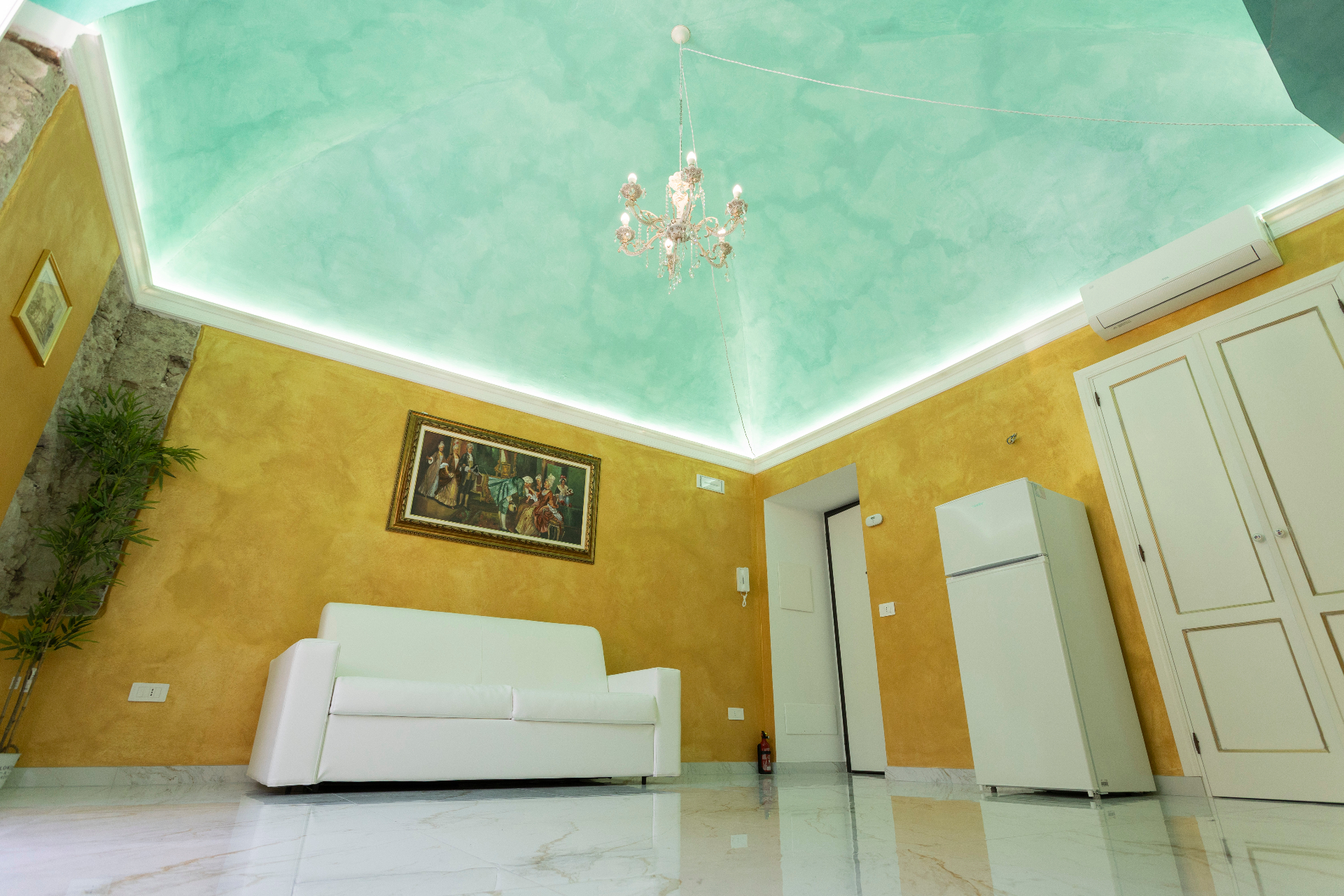 Salotto della suite con soffitto decorato acquamarina e pareti oro