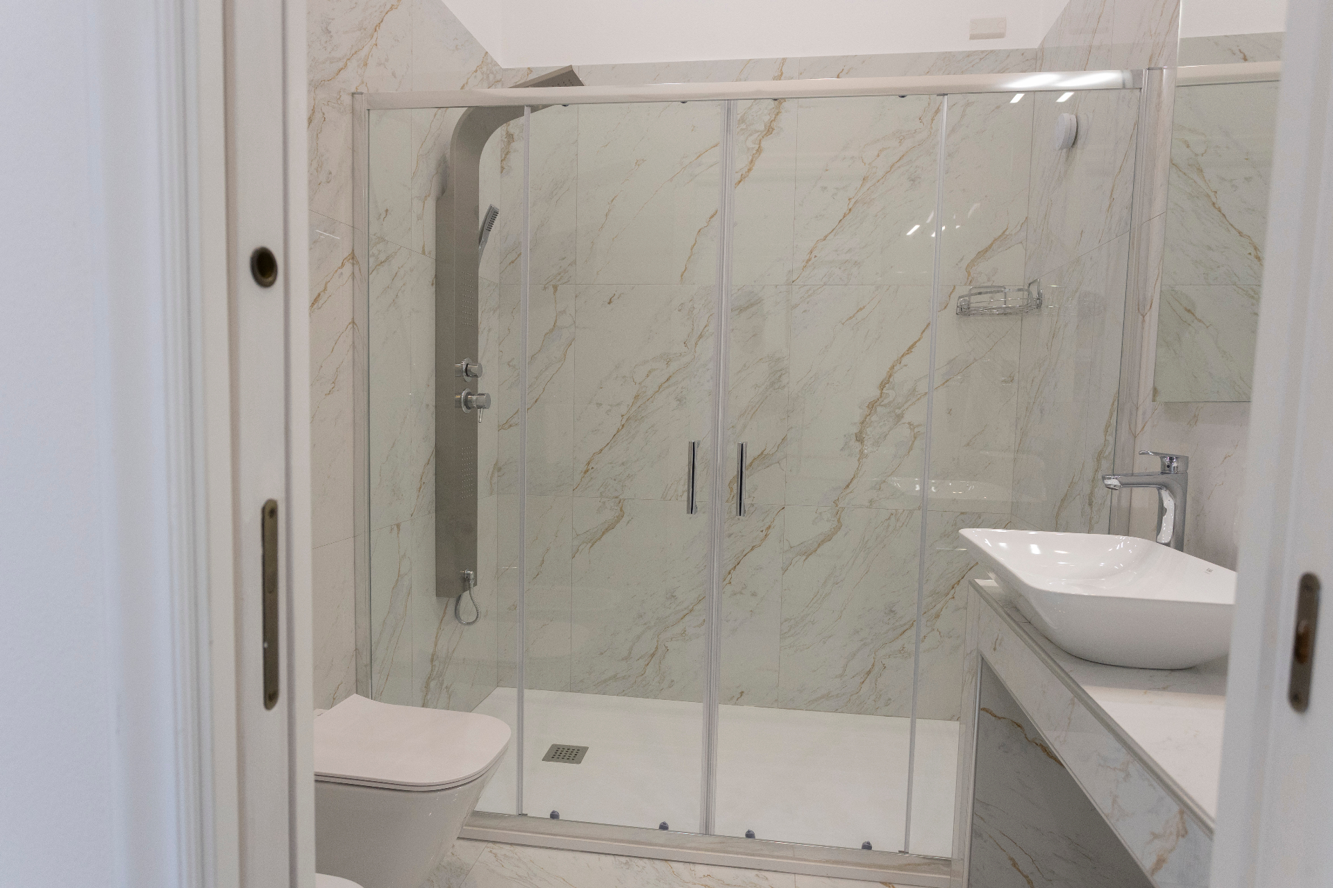 Suite Perla - bagno in marmo con doccia walk-in, sanitari sospesi e lavabo da appoggio
