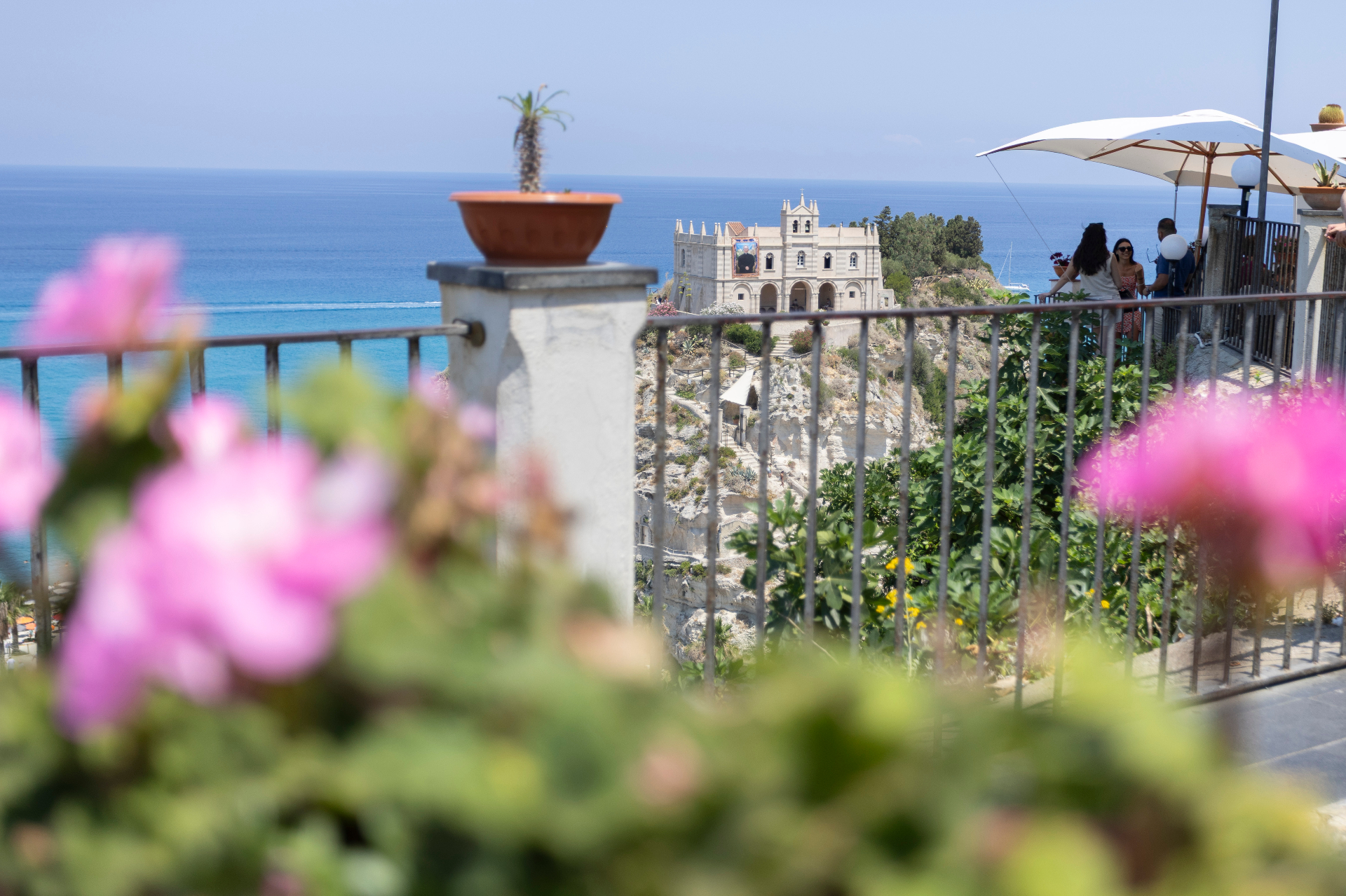 Terrazza panoramica con fiori e vista sul santuario di Tropea