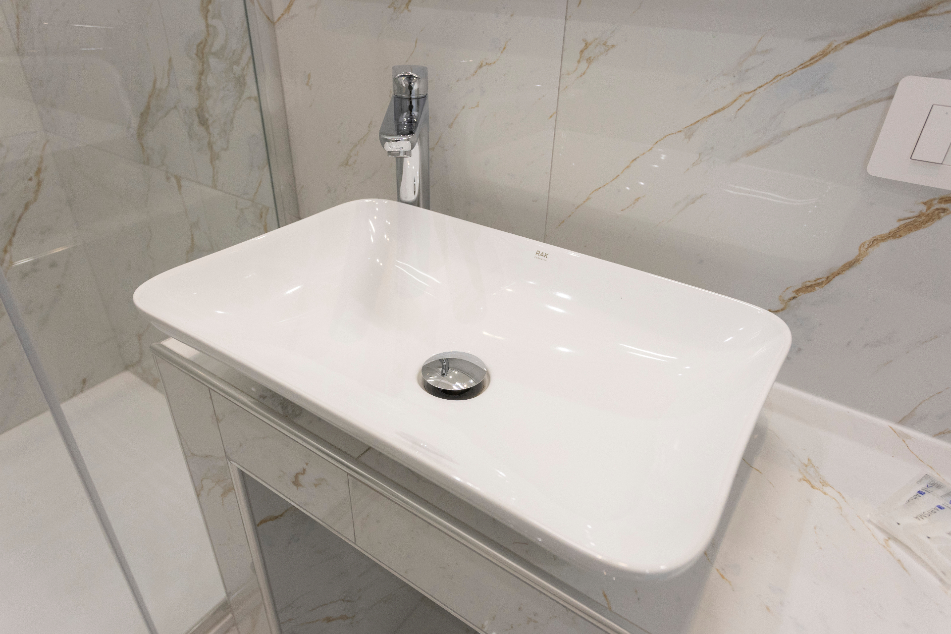 Suite Perla - dettaglio del lavabo da appoggio con rivestimento in marmo chiaro