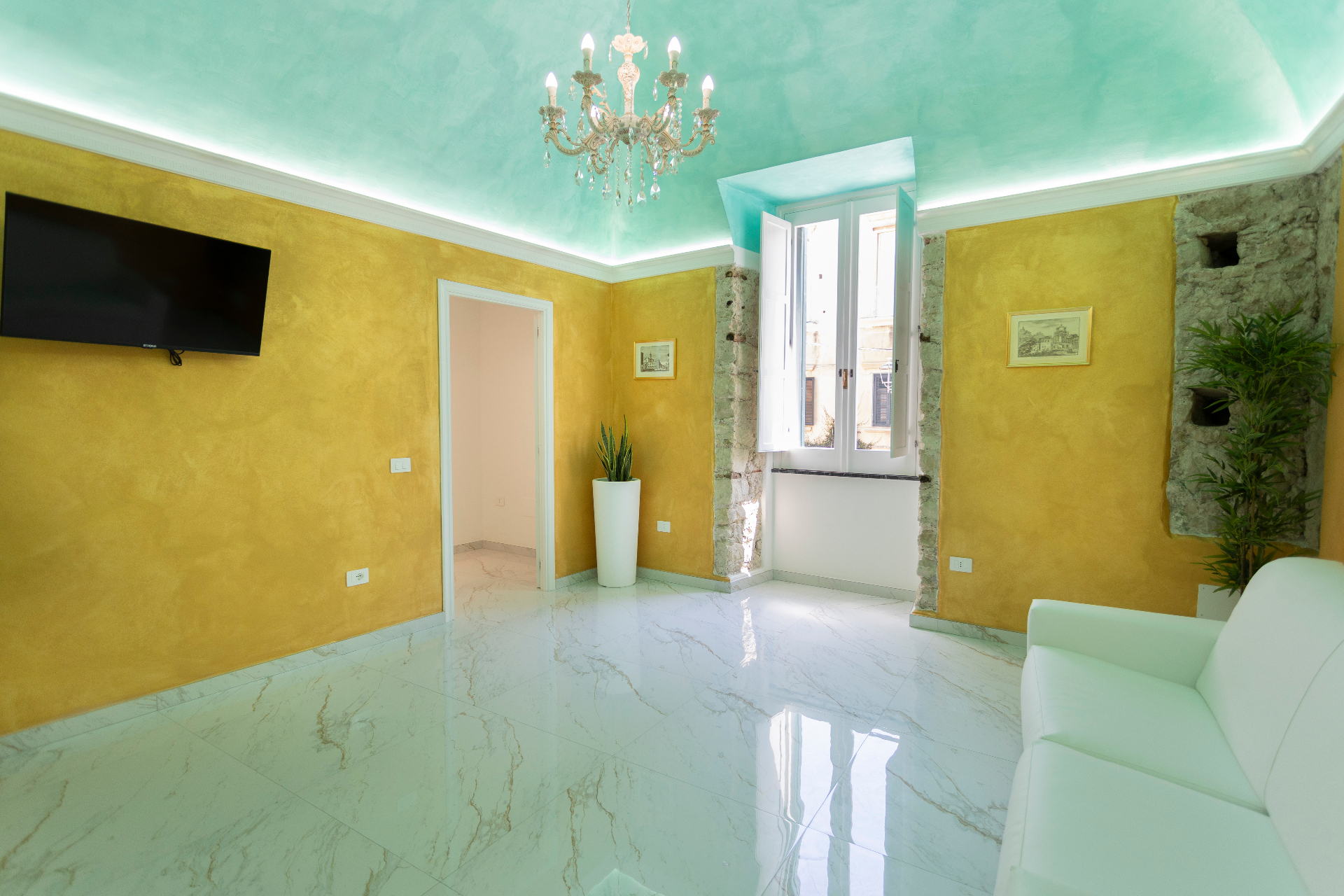 Suite Smeraldo - salotto con soffitto acquamarina, pareti oro e lampadario in cristallo