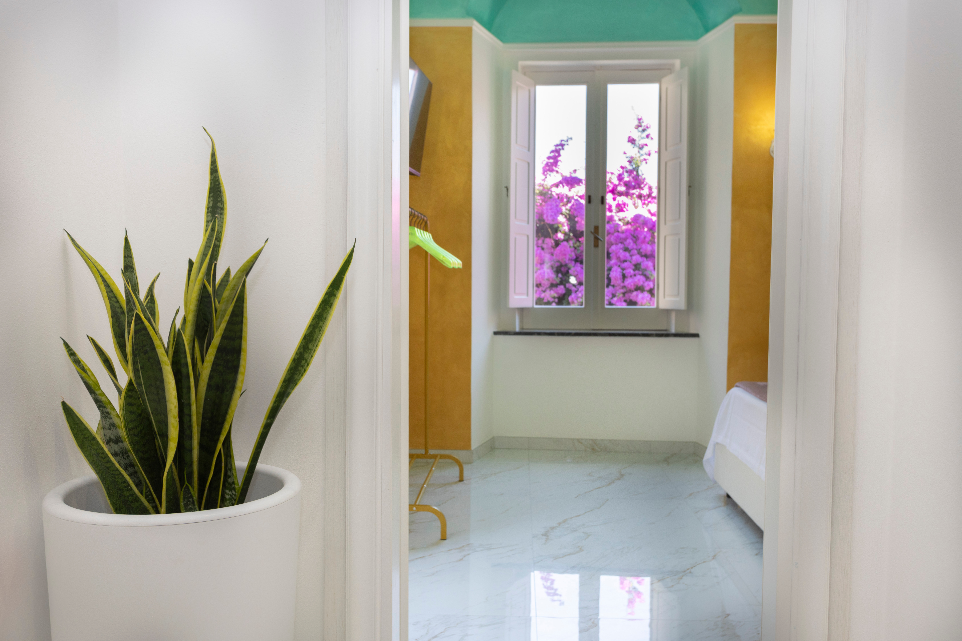 Suite Perla - ingresso verso la camera con vista sulla bouganville e soffitto acquamarina